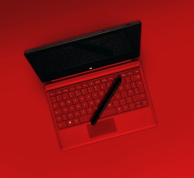 红色笔记本电脑上的黑笔